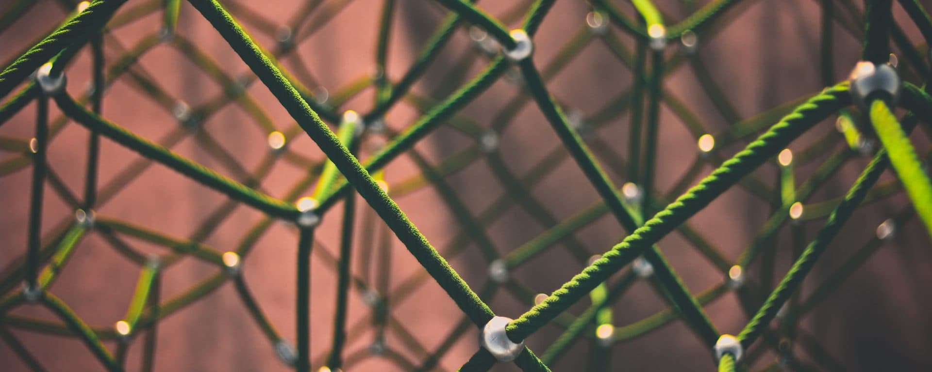 Close-up of a green rope climbing net with metal joints