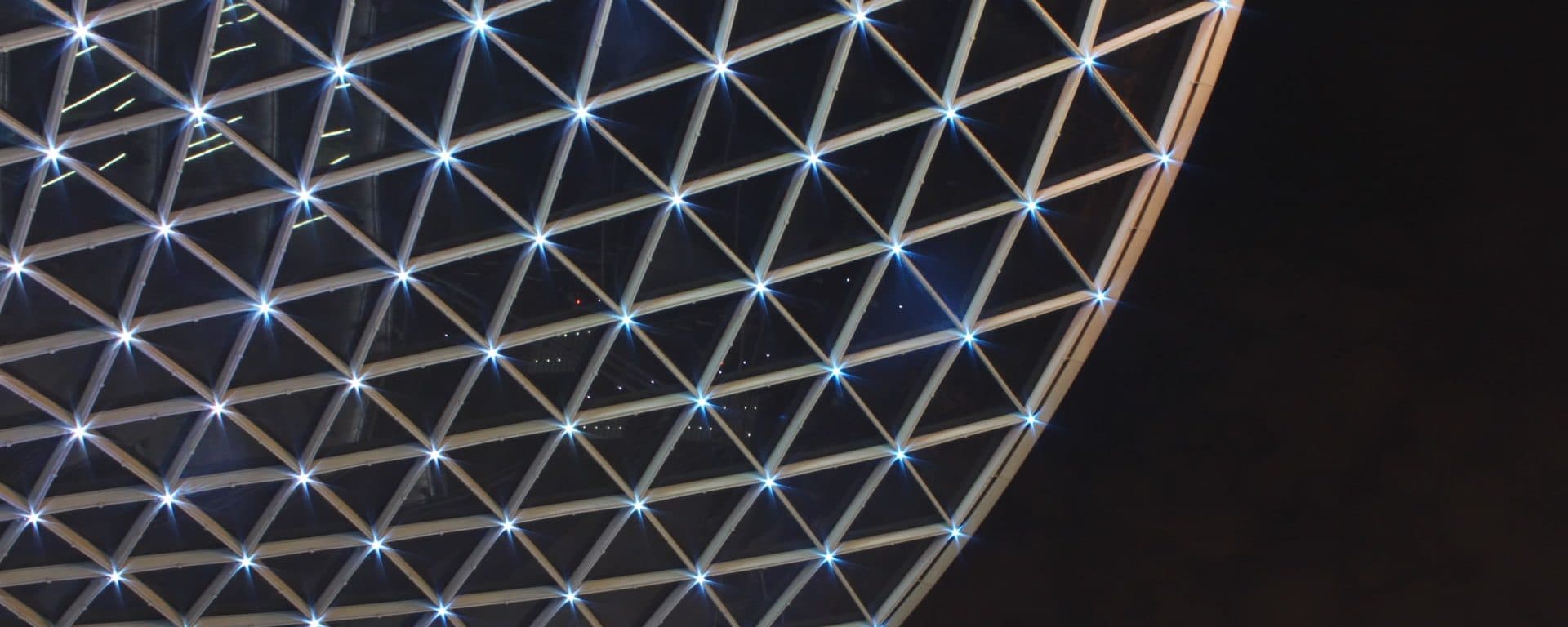 Geometric triangular light grid against a dark background