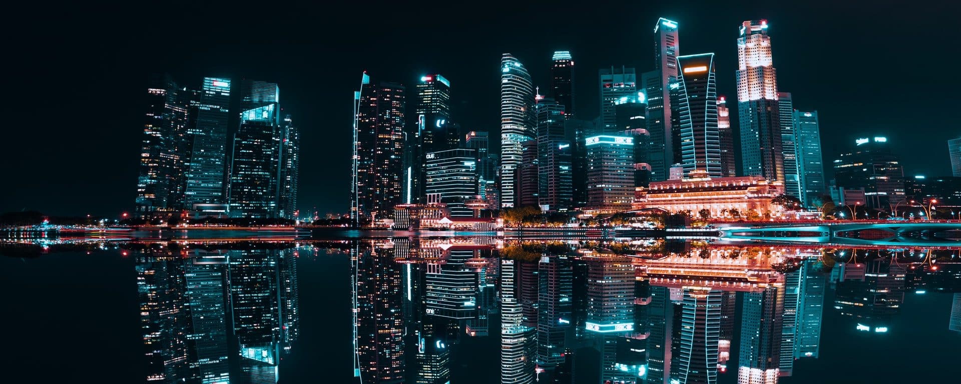 Illuminated city skyline reflected in water at night