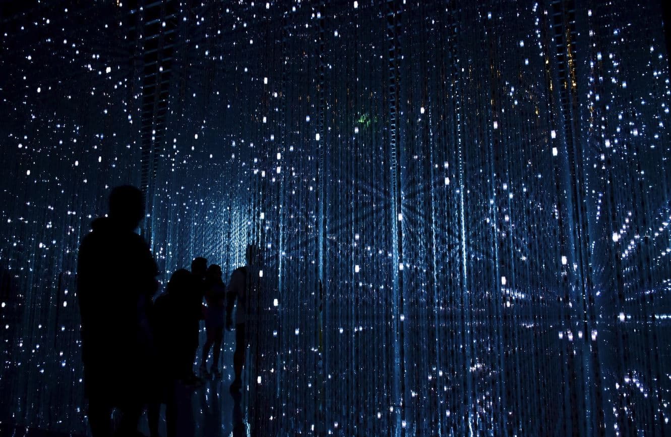 Silhouettes inside a blue mirrored light installation