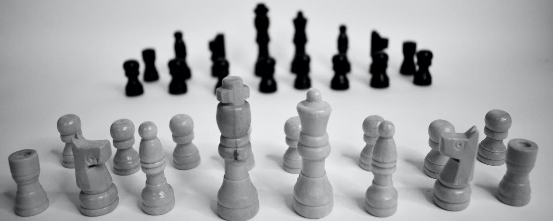 Black-and-white chessboard with white pieces facing black pieces